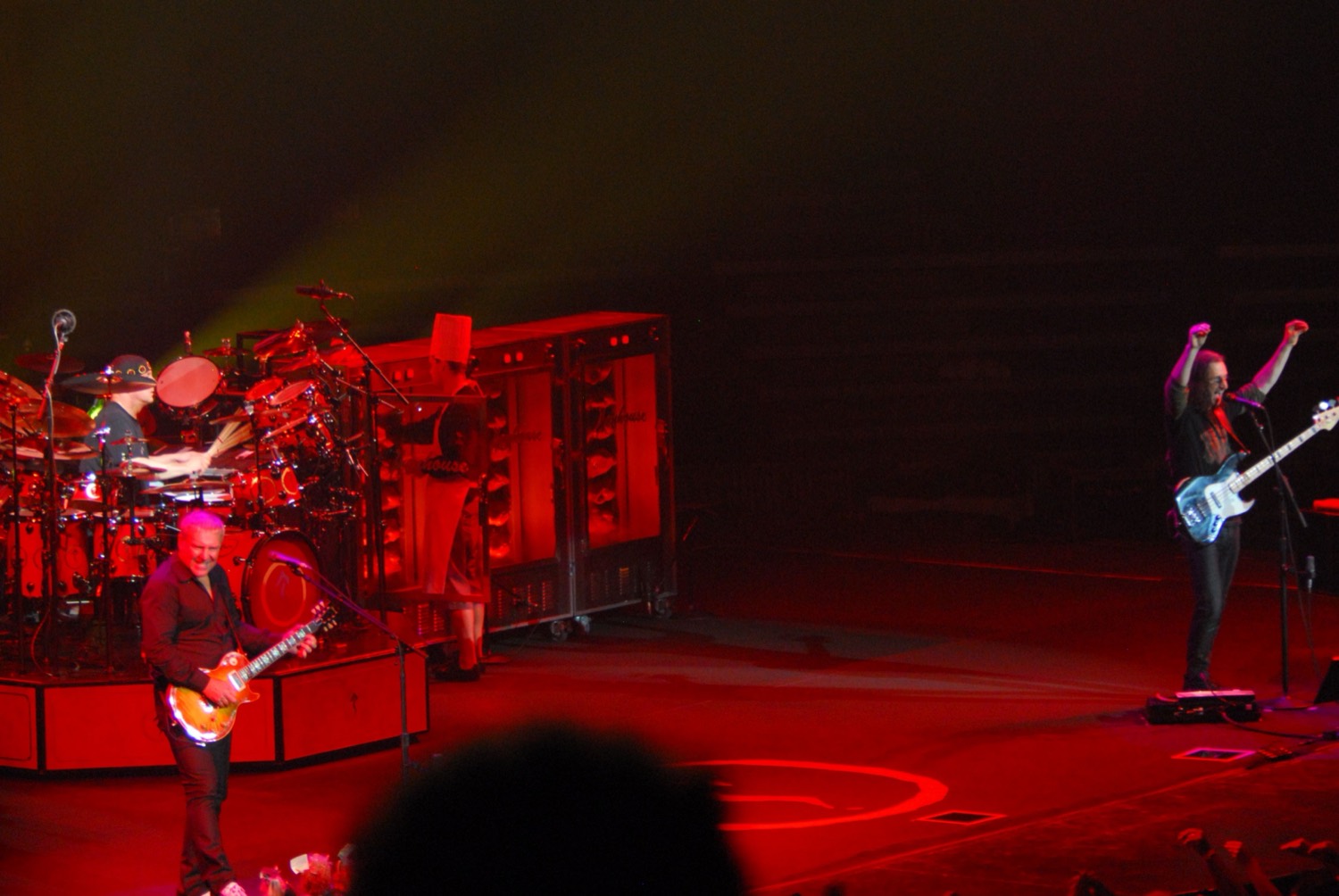 Rush on the Snakes and Arrows tour, stage lit red, with rotisserie oven cabinets standing where amplifiers would normally be.