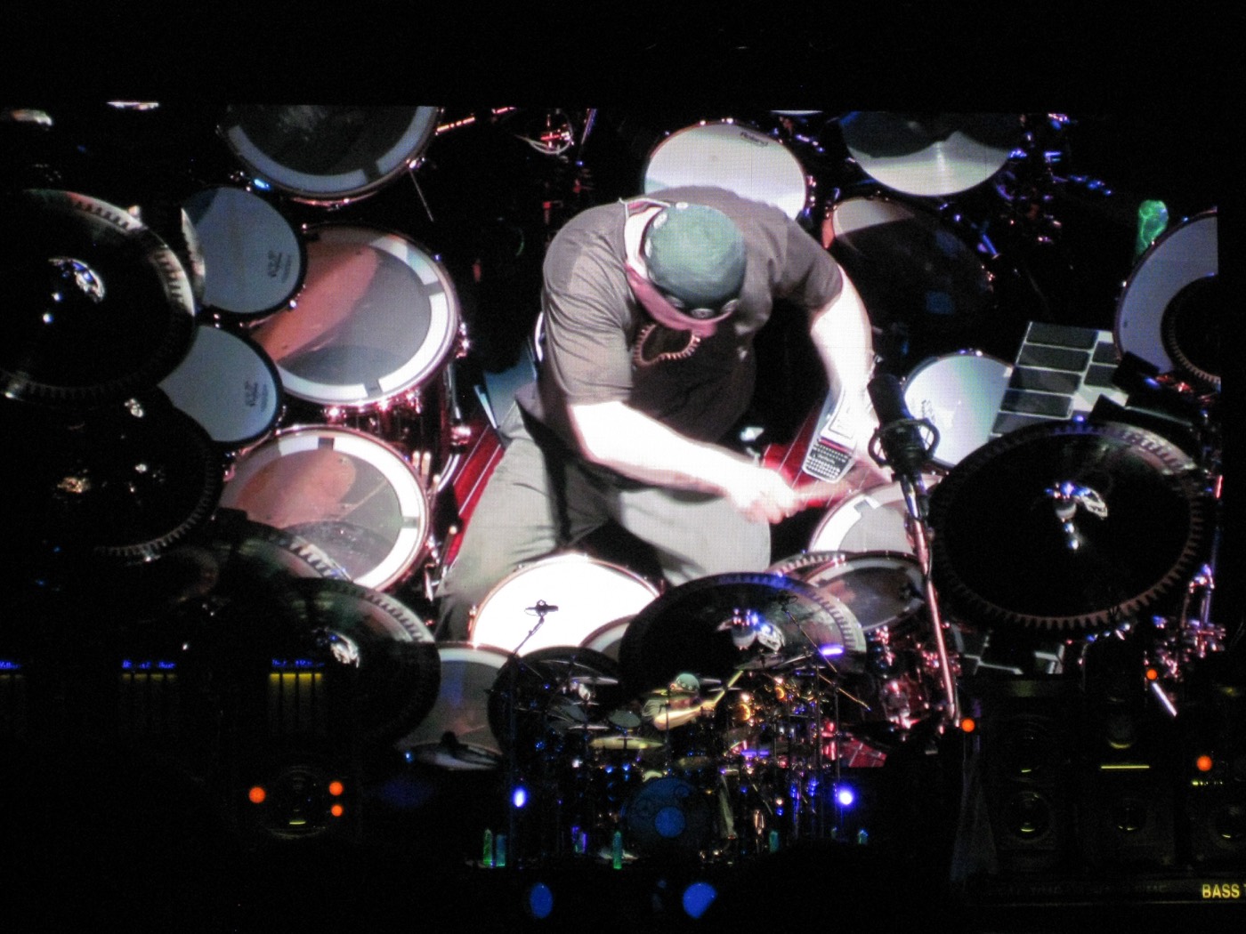 Neil Peart seen from above mid drum solo, surrounded by his kit, projected on the arena video screen.