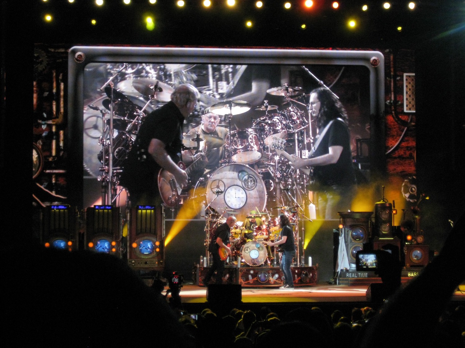 Rush performing on a large arena stage with video screen above, The Gorge Amphitheatre, 2011.